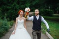 Exited newly wed couple walking down the path through a park Royalty Free Stock Photo