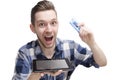 Exited young man, buying online via tablet, holding credit card in his hand Royalty Free Stock Photo