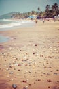 Exiting Anjuna beach panorama on low tide with white wet sand and green coconut palms, Goa, India Royalty Free Stock Photo