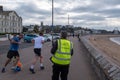 Exmouth, Devon, UK, April, 13, 2019: Running taking part in a Park Run event along the sea front at Exmouth, volunteer in the