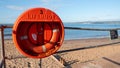 Exmouth, UK - August 03 2020: Lifebuoy ring attached to railings at the beach