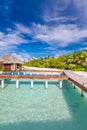 Exotic beach with water bungalows at Maldives, wooden bridge into paradise island Royalty Free Stock Photo