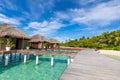 Exotic beach with water bungalows at Maldives, wooden bridge into paradise island Royalty Free Stock Photo