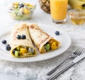 Exotic fruit crepes on a white plate surrounded by juice, honey and fruit. Royalty Free Stock Photo