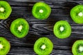 Exotic fruit pattern with sliced kiwi on dark table background t Royalty Free Stock Photo