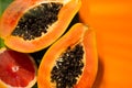 Exotic fruits background. Papaya and orange citrus fresh fruits on tropical leaf green background