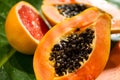 Exotic fruits background. Papaya and orange citrus fresh fruits on tropical leaf green background Royalty Free Stock Photo