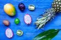 Exotic fruits. Pineapple, dragonfruit, mangosteen, mango, kiwi and lime on blue wooden background top view