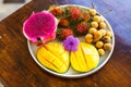 Exotic fruits on plate: mango, dragon fruit; mango; pineapple an Royalty Free Stock Photo