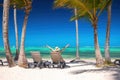 Exotic island beach with palm trees and sun lounges on the Caribbean Sea shore, summer tropical vacation Royalty Free Stock Photo