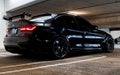 Exotic metallic black BMW M3 CS m power sports rear car with bright cherry red lights