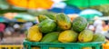 Exotic papayas displayed with umbrellas and palm leaves in tropical market stall, vacation vibes