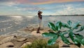 Beautiful women with summer hat and yellow dress sunset pink sky relaxing stay on rock stone at pier beach sea water seagull