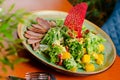 Exotic salad with duck breast, mango, fresh arugula and lettuce. Restaurant serving