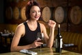 Exotic beautiful woman on a dinner date at winery barrels enjoying evening night out