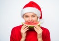 Exotic winter holiday. Girl wear santa hat eat slice watermelon white background. Celebrate new year summer. Summer Royalty Free Stock Photo