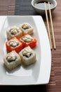 Exotically japanese seafood, roll are lying on a white plate.