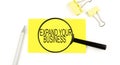 EXPAND YOUR BUSINESS text on the sticker through magnifier. View from above. Business concept Royalty Free Stock Photo