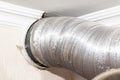 Expandable metallic aluminium corrugated air-conditioning ventilation pipe in kitchen connecting a cooker hood and a ventilation