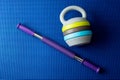 An expander and adjustable kettlebell on blue yoga mat background