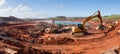 Expansive aerial view of a massive quarry mining operation extracting iron ore resources