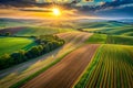 Rolling Agricultural Fields Under a Dramatic Sunset Sky with Sunburst Royalty Free Stock Photo