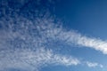 Expansive blue sky displaying diverse patterns of soft white altocumulus and wispy cirrus clouds, symbolizing natural freedom and Royalty Free Stock Photo