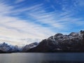 Expansive fjord in the Lofoten Islands surrounded with snowy mountains and blue sky. Norway.