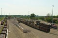 Expansive freight station under daylight with numerous wagons and equipment Royalty Free Stock Photo