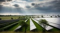 Expansive Solar Farm Under Dramatic Cloudy Sky with Sun Rays Royalty Free Stock Photo