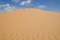 Yellow sand dunes with wavy textures against a blue sky in Swakopmund Royalty Free Stock Photo