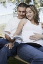 Expectant Couple Sitting On Bench Royalty Free Stock Photo