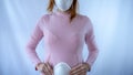 A young pregnant woman is wearing a mask and staying sick at home