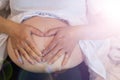 The expectant mother puts her hands on her belly to communicate with her unborn child and wait for the day when her baby is born.