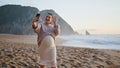 Expectant mother video call by cellphone at beach. Happy pregnant woman greeting Royalty Free Stock Photo