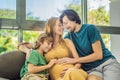 Expectant parents, mom, dad, and their eldest son share a heartwarming moment on the sofa, discussing the exciting Royalty Free Stock Photo