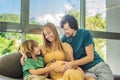 Expectant parents, mom, dad, and their eldest son share a heartwarming moment on the sofa, discussing the exciting Royalty Free Stock Photo