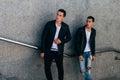 Sexy mans posing near railing. Handsome young mans in stylish black clothes and white shoes posing near a railing. friendship Royalty Free Stock Photo