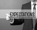 Expectations. Businessman in a suit with a marker writing on visual screen Royalty Free Stock Photo