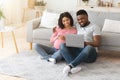 Expecting black family spending time together at home, using laptop Royalty Free Stock Photo