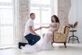 In expecting. Happy pregnant pair in fashion clothes posing in studio