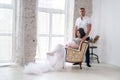 In expecting. Happy pregnant pair in fashion clothes posing in studio