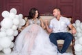 In expecting. Happy pregnant pair in fashion clothes posing in studio