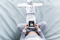 Expecting pregnant woman touching her belly while looking at ultrasound scans, sitting on cozy bed with blankets, pillows, kid Royalty Free Stock Photo