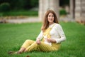 Expecting young female mother posing in park holding plush toy