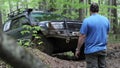 Expeditionary SUV got stuck in the forest and trying to get out via winch.