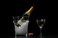 An expensive bottle of champagne in a transparent bucket filled with ice on a black background. Celebration concept. Royalty Free Stock Photo