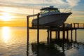 Expensive fishing boat on motorized electric dock vessel lift at sunrise