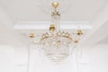 Expensive interior. Large electric chandelier made of transparent glass beads. White ceiling decorated with stucco Royalty Free Stock Photo