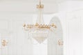 Expensive interior. Large electric chandelier made of transparent glass beads. White ceiling decorated with stucco Royalty Free Stock Photo